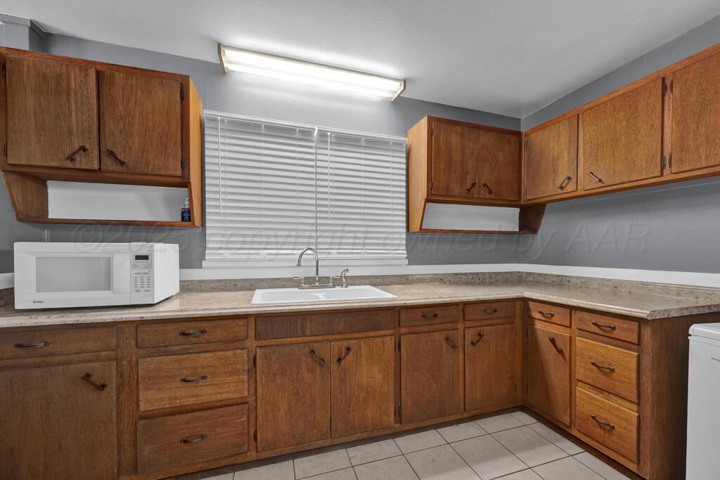 2909 South Marrs Street Amarillo, TX 79103 - Photo 7 of 21 a kitchen with cabinets appliances a sink and a window