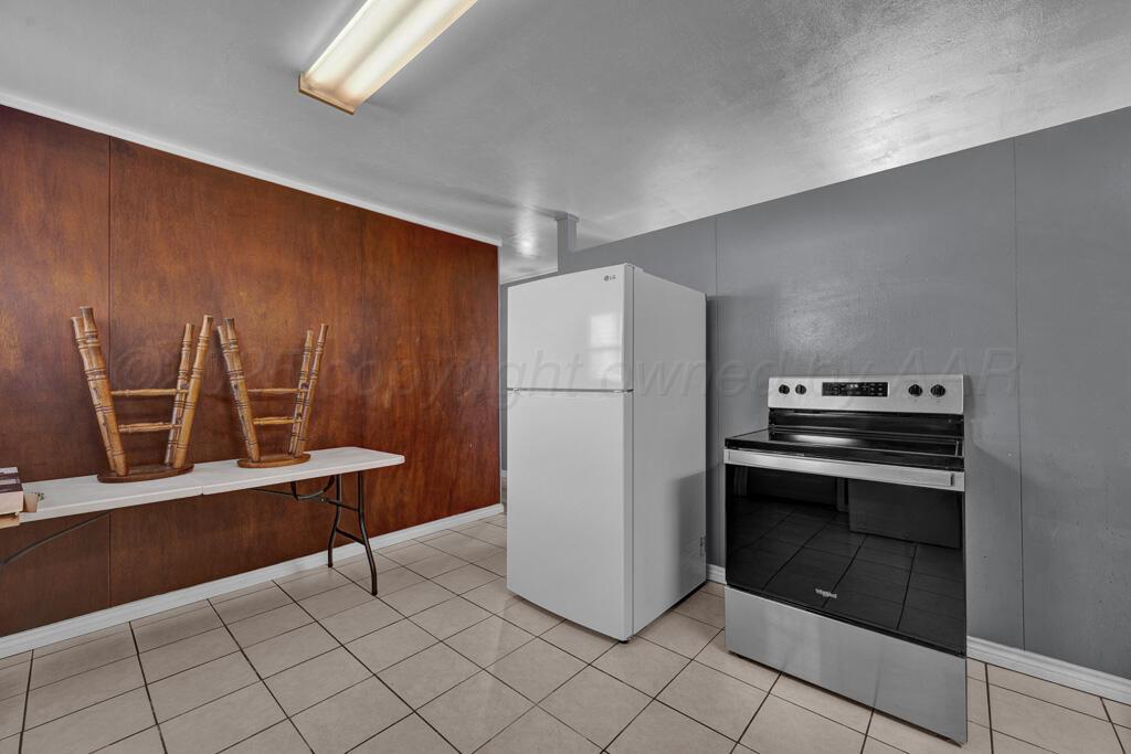 2909 South Marrs Street Amarillo, TX 79103 - Photo 8 of 21 a kitchen with granite countertop a refrigerator and a stove top oven