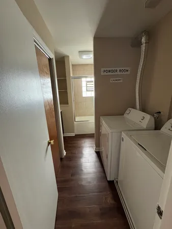 a utility room with wooden floor washer and dryer