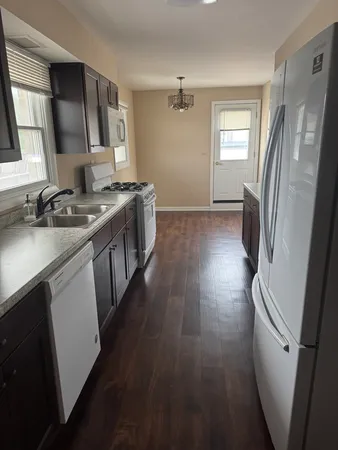 a kitchen with sink a refrigerator and a stove