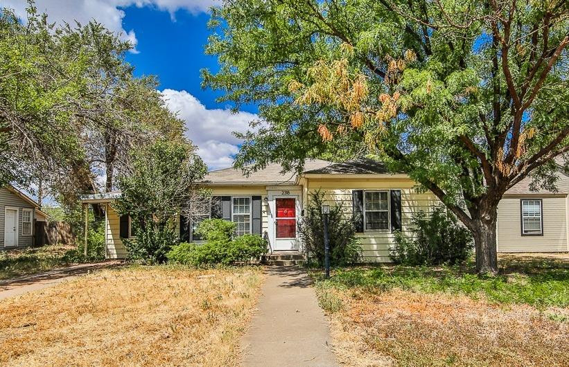a front view of house with yard and trees around