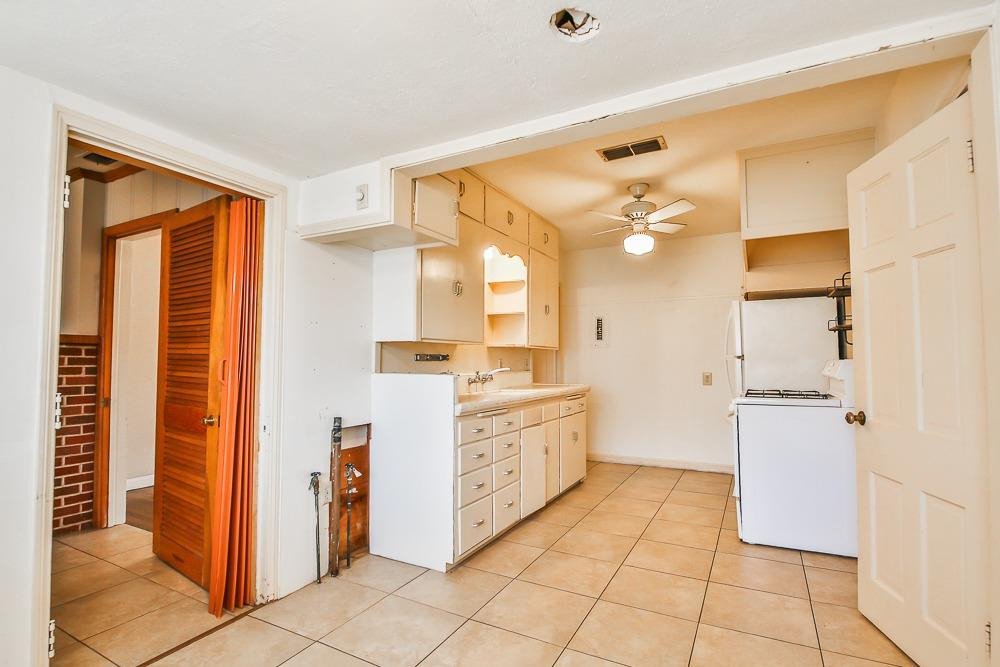 2318 29th Street Lubbock, TX 79411 - Photo 12 of 32 a bathroom with a granite countertop sink a mirror and a shower