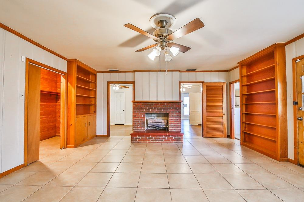 2318 29th Street Lubbock, TX 79411 - Photo 16 of 32 a view of an empty room with a fireplace and a chandelier fan