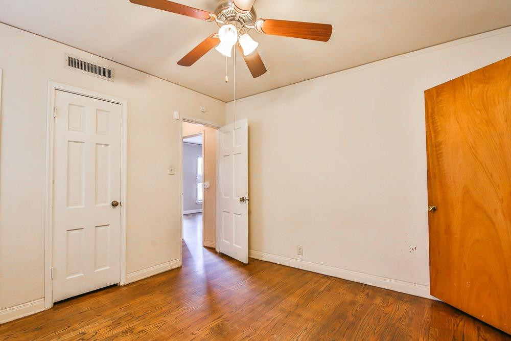 2318 29th Street Lubbock, TX 79411 - Photo 21 of 32 an empty room with wooden floor and door