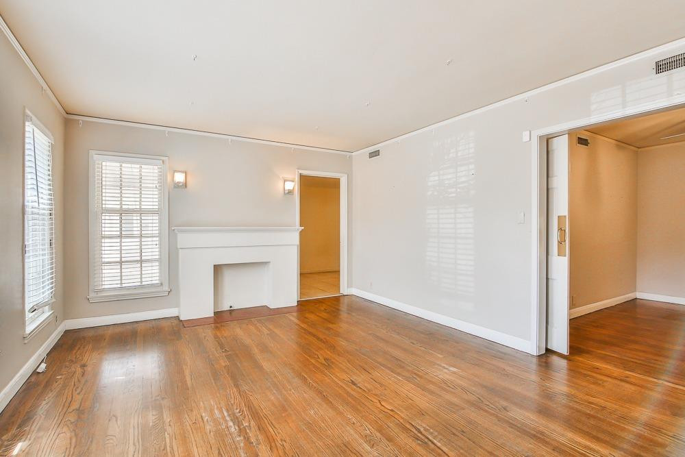 2318 29th Street Lubbock, TX 79411 - Photo 3 of 32 an empty room with wooden floor cabinet and windows