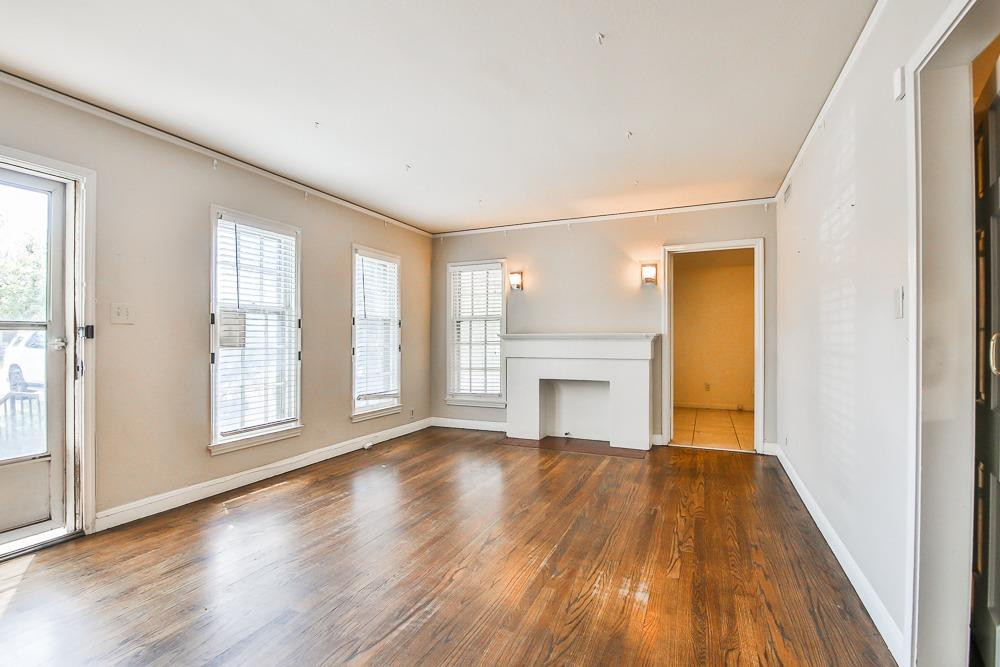 2318 29th Street Lubbock, TX 79411 - Photo 4 of 32 a view of an empty room with wooden floor and a window