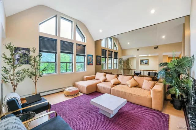 a living room with furniture fireplace and a large window