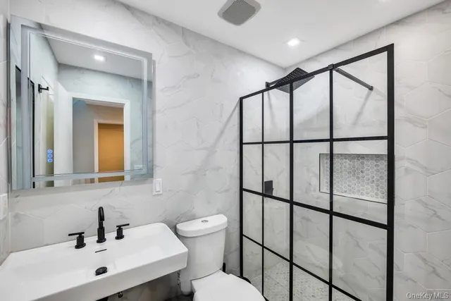 a bathroom with a toilet sink shower and mirror