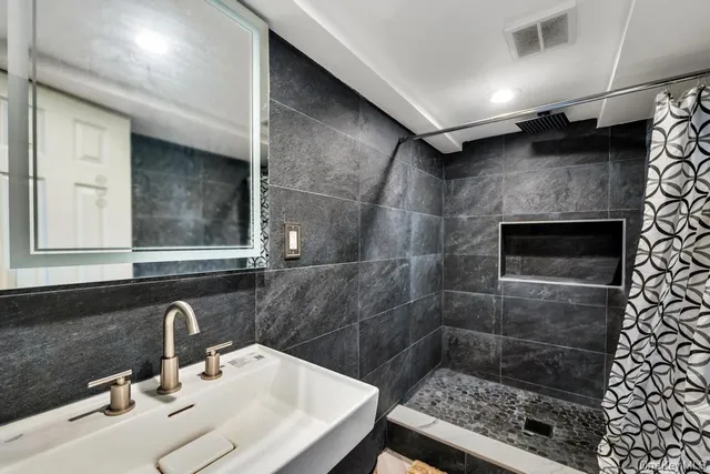 a bathroom with a sink a toilet and shower