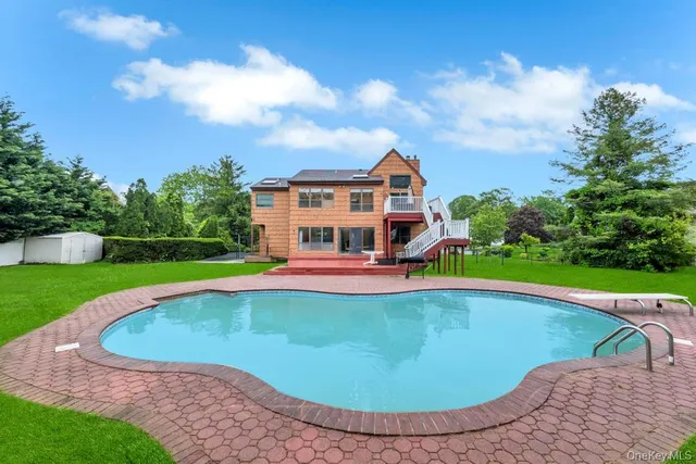 a view of a house with swimming pool and yard