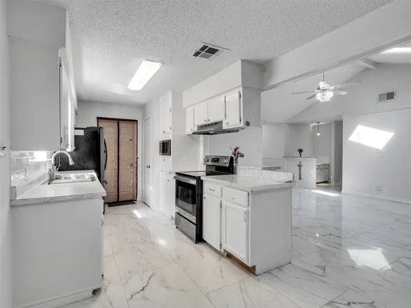 a kitchen with white cabinets and appliances