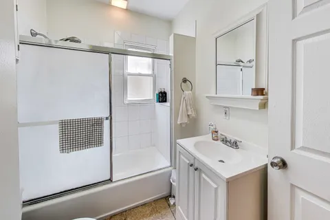 a bathroom with a sink mirror and shower