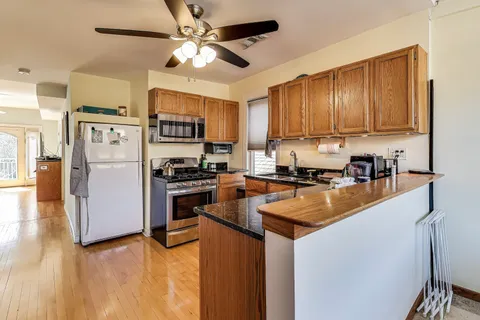 a kitchen with stainless steel appliances granite countertop a refrigerator a stove a sink and a microwave