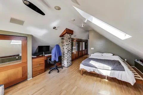 a bedroom with bed and a flat tv screen on dresser