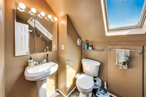 a bathroom with a toilet a sink and a mirror