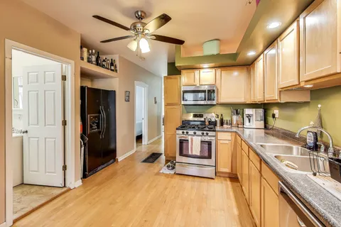 a kitchen with stainless steel appliances granite countertop a sink cabinets and refrigerator