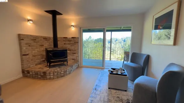 a living room with furniture a flat screen tv and a floor to ceiling window