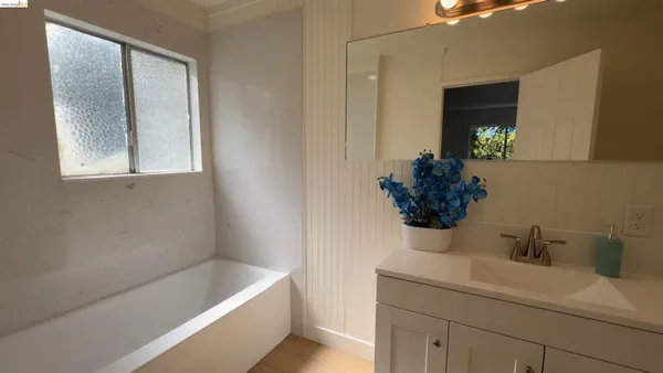 a bathroom with a bathtub sink and mirror