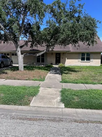 a front view of house with yard and trees