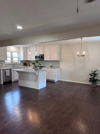 a kitchen with stainless steel appliances granite countertop a sink a stove top oven a counter space and cabinets