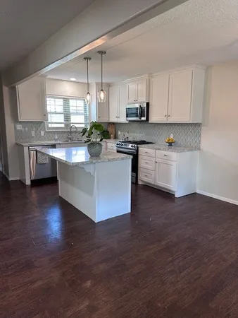 a kitchen with stainless steel appliances granite countertop a stove a sink and a refrigerator