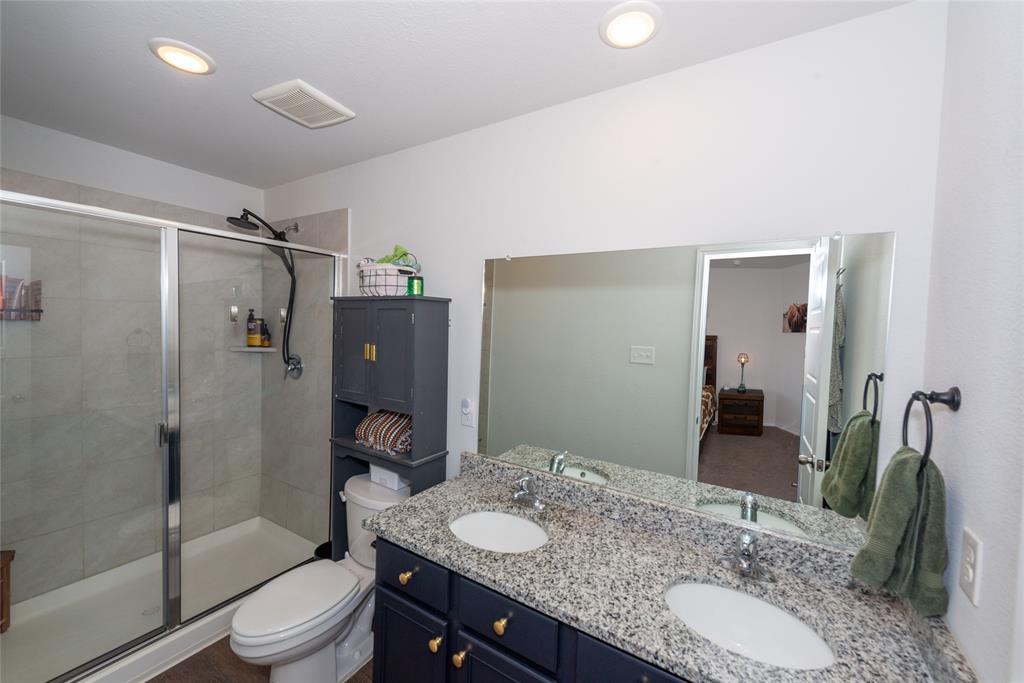 431 Woodhouse Way Everman, TX 76140 - Photo 18 of 30 a bathroom with a granite countertop sink toilet and shower