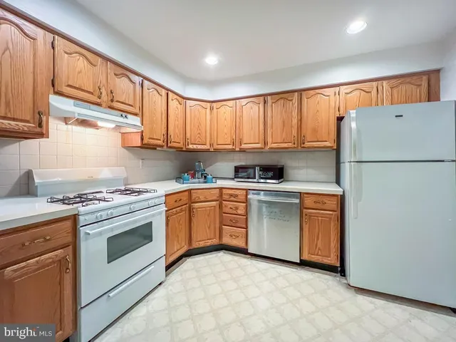a kitchen with granite countertop a sink stainless steel appliances and cabinets