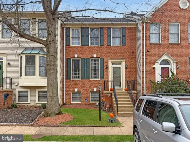 a view of a brick house with many windows and a yard