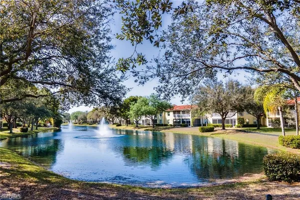a view of residential houses with lake and trees