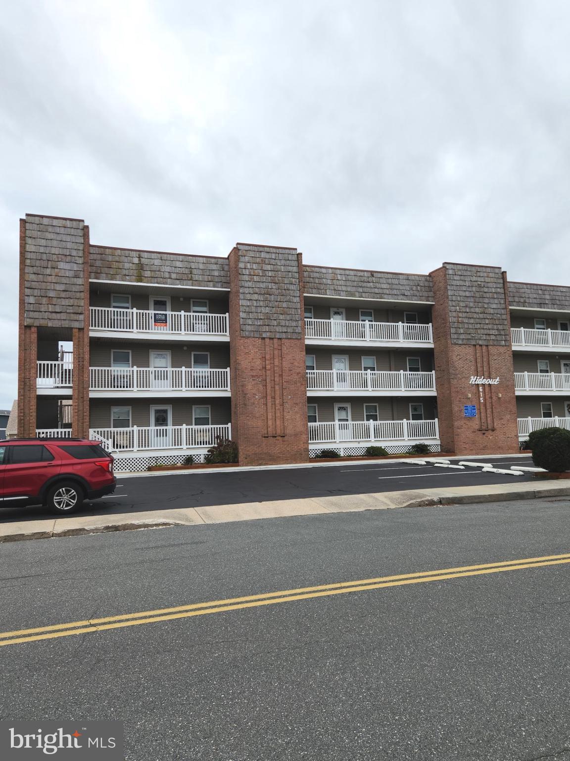 615 Salt Spray Road, Unit 3A Ocean City, MD 21842 - Photo 2 of 23 a front view of a building with lot of cars and trees