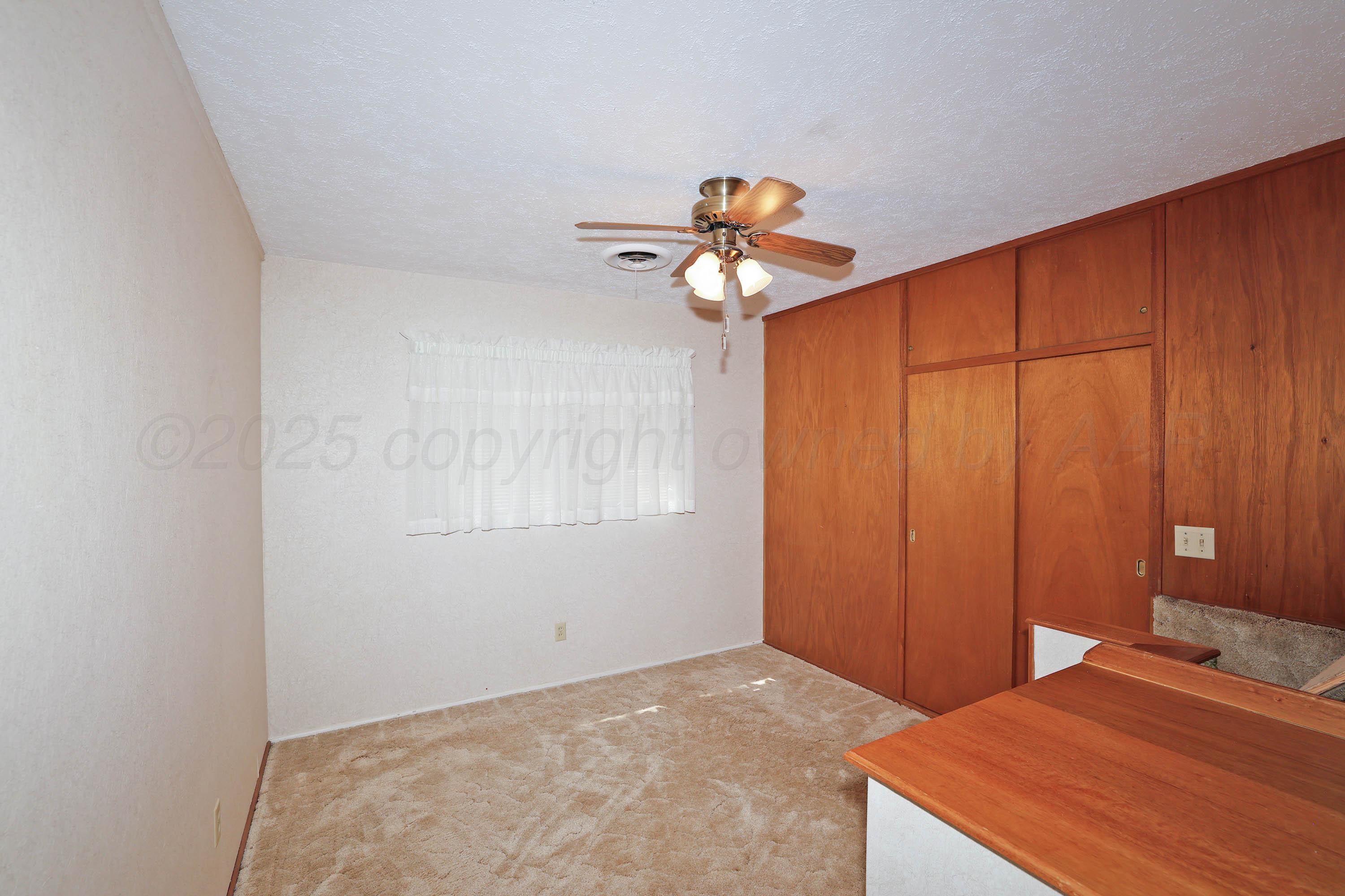 5119 South Bonham Street Amarillo, TX 79110 - Photo 19 of 32 a bedroom with a bed and a chandelier