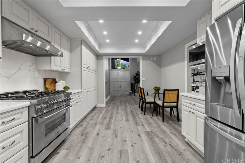 23524 Highland Glen Drive Newhall, CA 91321 - Photo 14 of 53 a kitchen with stainless steel appliances a stove a refrigerator and wooden floor