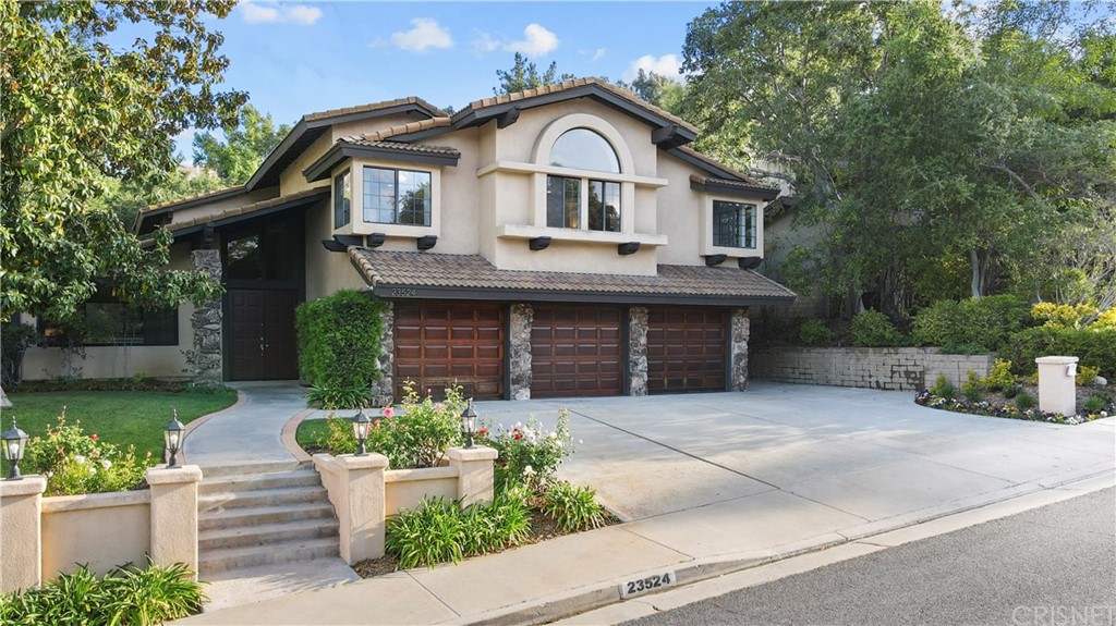 23524 Highland Glen Drive Newhall, CA 91321 - Photo 3 of 53 a front view of a house with a garden and plants
