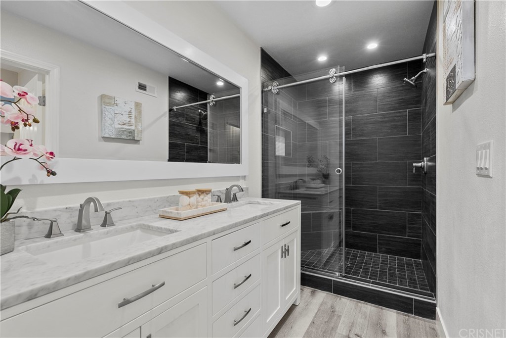 23524 Highland Glen Drive Newhall, CA 91321 - Photo 34 of 53 a bathroom with a shower sink and mirror
