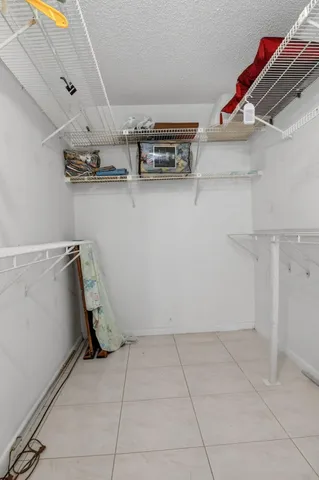 an empty room with chandelier fan and windows