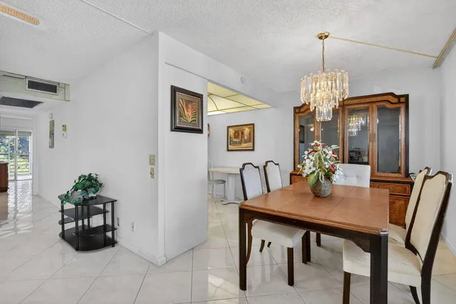 an empty room with chandelier fan and windows