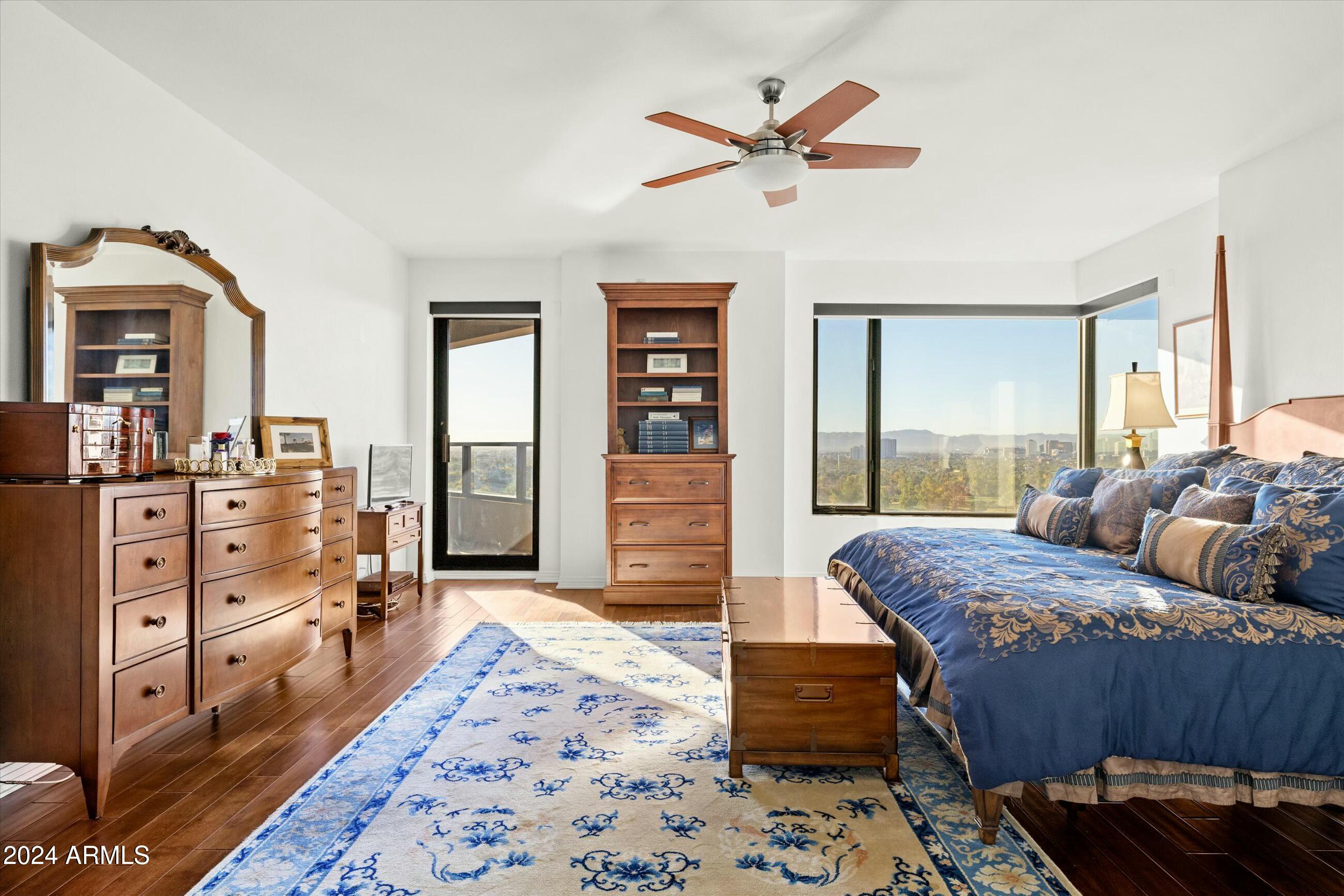 1040 East Osborn Road, Unit 1201 Phoenix, AZ 85014 - Photo 13 of 28 a bedroom with a bed and wooden floor