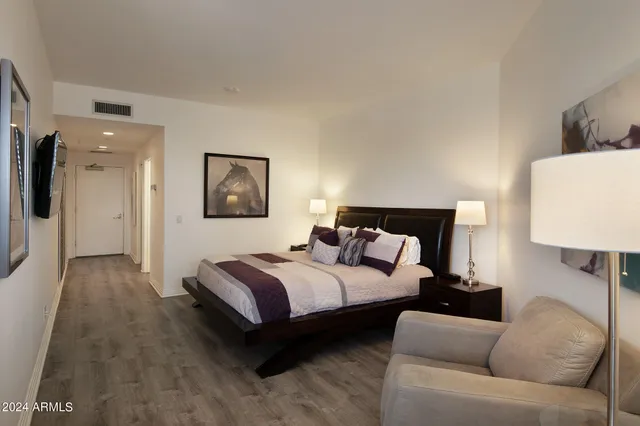 a spacious bedroom with a bed and a lamp