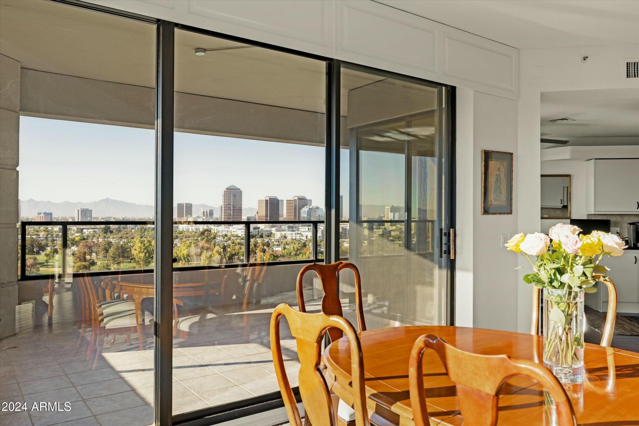 1040 East Osborn Road, Unit 1201 Phoenix, AZ 85014 - Photo 5 of 28 a dining room with furniture and floor to ceiling window