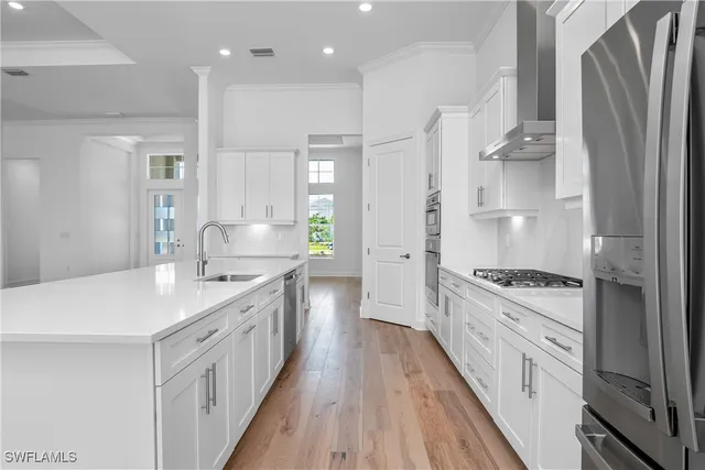 a kitchen with stainless steel appliances a sink stove and refrigerator
