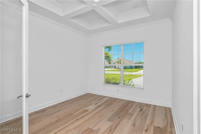 an empty room with a window and wooden floor