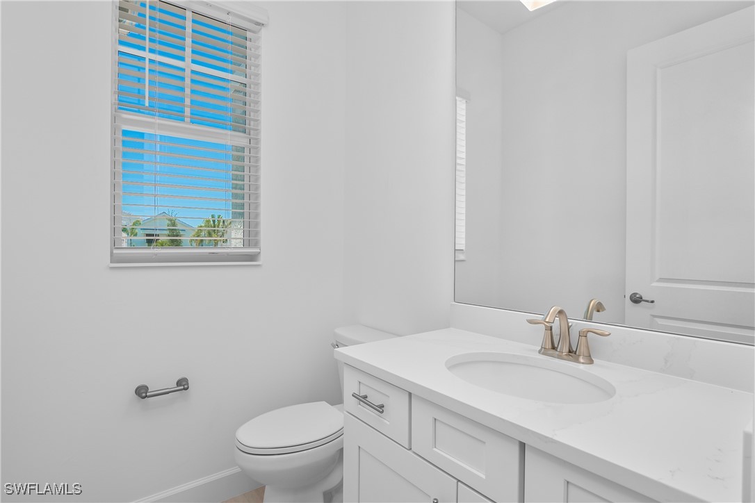 18837 WildBlue Boulevard Fort Myers, FL 33913 - Photo 18 of 49 a bathroom with a sink a toilet and a window