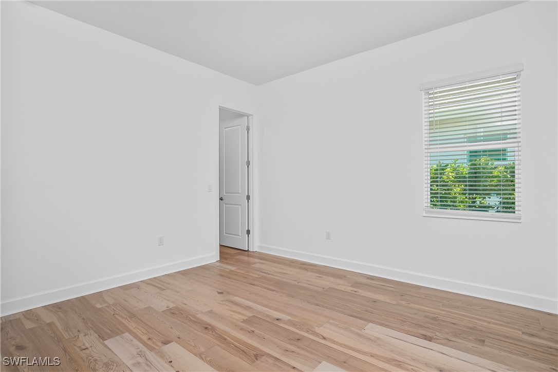 18837 WildBlue Boulevard Fort Myers, FL 33913 - Photo 25 of 49 an empty room with wooden floor and windows