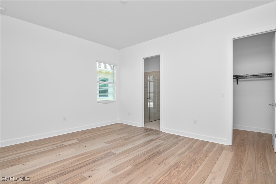 18837 WildBlue Boulevard Fort Myers, FL 33913 - Photo 27 of 49 an empty room with wooden floor and windows
