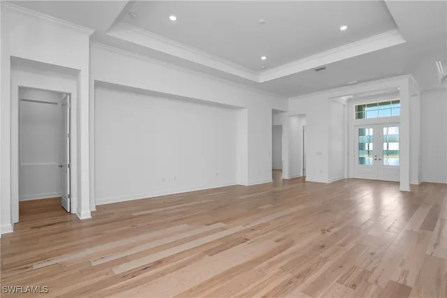 a view of an empty room with wooden floor and closet
