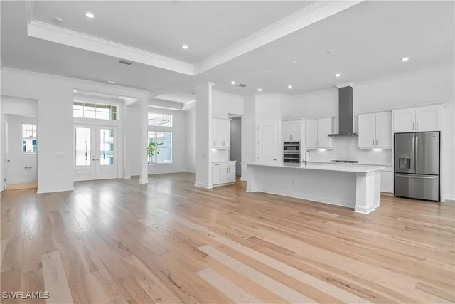 a view of kitchen with kitchen island wooden floors refrigerator and cabinets