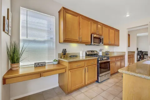a kitchen with stainless steel appliances granite countertop a sink a stove and a microwave