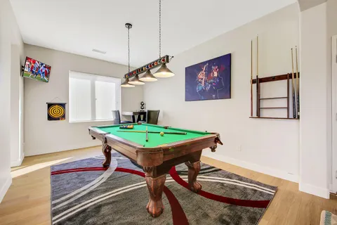 a room with pool table and windows