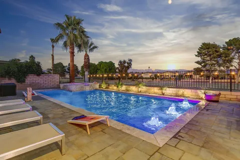 swimming pool with chairs and table on the patio