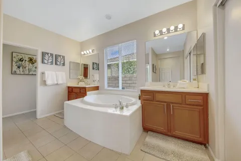 a spacious bathroom with a sink a large mirror and a bathtub